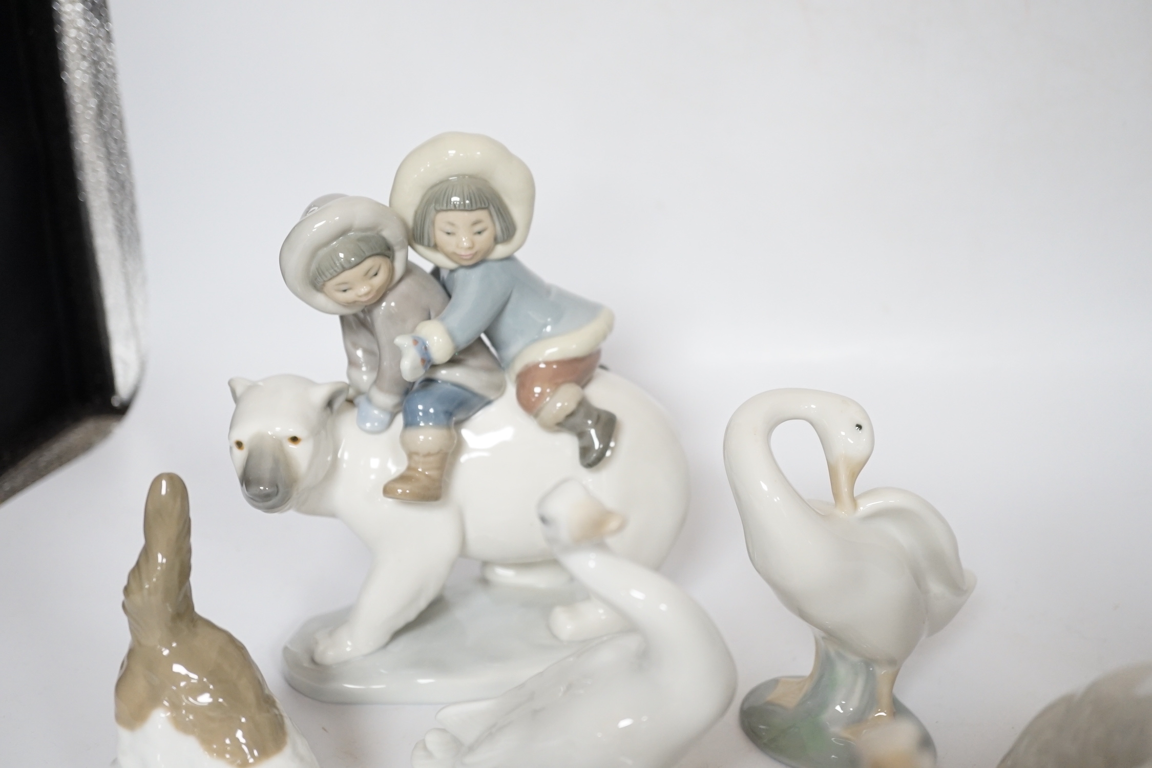 Eleven Lladro figure groups, including a collection of ducks, two Eskimo figure groups, a sleeping child with teddy on a cushion etc, none boxed